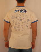 Person wearing a beige regular fit t-shirt with blue text and graphics on the back against a plain background