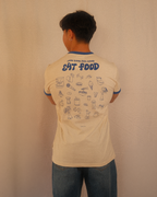 Person wearing a beige regular fit t-shirt with food-themed graphics and text on the back, standing against a plain background.