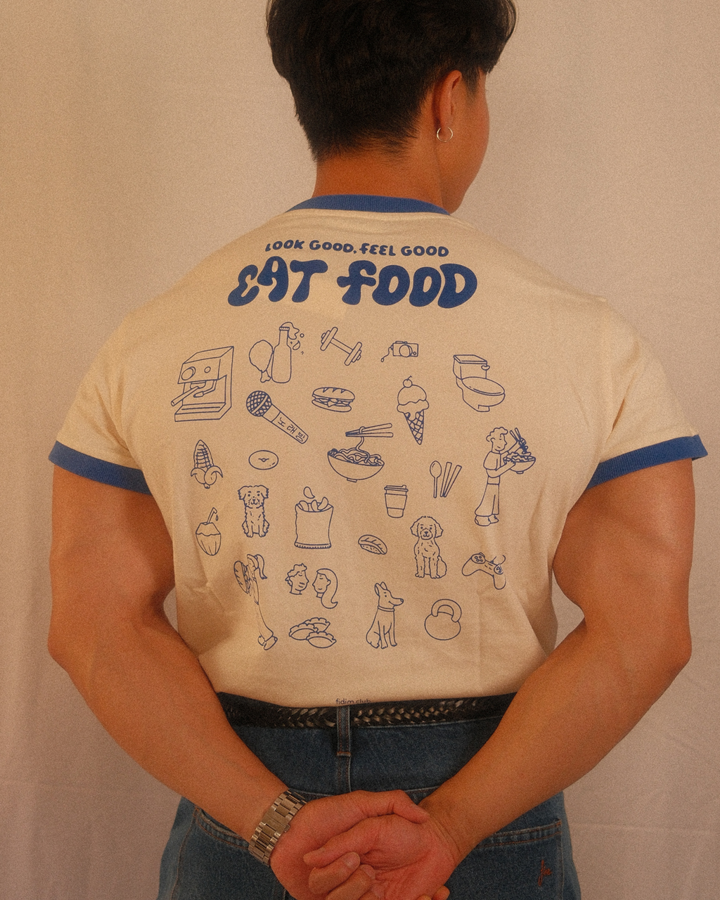 Person wearing a regular fit t-shirt with illustrations and text on the back against a plain background